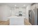 Open kitchen showcasing an island with sink, stainless steel appliances, and white cabinets at 3727 Rosebush Dr, Zebulon, NC 27597