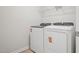 Bright laundry room features a side-by-side washer and dryer with a wire rack for additional storage at 3727 Rosebush Dr, Zebulon, NC 27597
