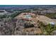 This aerial view showcases the property and its surroundings, highlighting the buildings and ample wooded acreage at 3817 Nc-119, Mebane, NC 27302