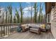 Outdoor deck featuring a hot tub, comfortable seating, a wooden deck, and serene views of the wooded property at 3817 Nc-119, Mebane, NC 27302