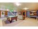 Finished basement featuring a billiard table, comfortable seating, a stone accent wall, and ample lighting at 3817 Nc-119, Mebane, NC 27302