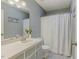 Cozy bathroom with a large mirror, patterned tile floor, and a tub-shower with a white shower curtain at 3817 Nc-119, Mebane, NC 27302