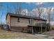 Back of home featuring deck, walkout basement, brick accents, and a peaceful, private backyard at 3817 Nc-119, Mebane, NC 27302
