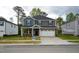 Charming two-story home with a brick and siding facade, attached garage, and well-manicured front yard at 3821 Rosebush Dr, Zebulon, NC 27597
