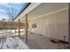Covered back porch with wooden support posts, a brick wall and concrete floor at 410 N Lamar St, Roxboro, NC 27573