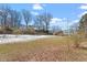 Large grassy backyard with mature trees and landscaping and snow on the ground at 410 N Lamar St, Roxboro, NC 27573