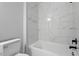 This bright bathroom features white marble tile, a tub, and sleek dark fixtures at 410 N Lamar St, Roxboro, NC 27573