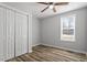 A neutral bedroom with luxury vinyl plank flooring, a ceiling fan, a closet, and a large window at 410 N Lamar St, Roxboro, NC 27573