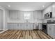 Modern kitchen with stainless steel appliances, ample white cabinetry, and subway tile backsplash at 410 N Lamar St, Roxboro, NC 27573