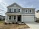 Charming two-story home with a grey exterior, a two-car garage, and a well-maintained front yard at 4120 Shadbush St, Raleigh, NC 27616