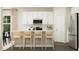 Bright kitchen with a center island, stainless steel appliances, white cabinets, and stylish wooden bar stools at 4120 Shadbush St, Raleigh, NC 27616