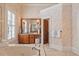 Bathroom with soaking tub, wood cabinets, and plantation shutters at 4708 Wynneford Way, Raleigh, NC 27614
