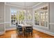 Dining room boasts large windows providing ample natural light, hardwood floors and chandelier at 4708 Wynneford Way, Raleigh, NC 27614