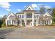 Stately two-story home with a circular driveway, elegant columns, and mature landscaping at 4708 Wynneford Way, Raleigh, NC 27614