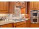 Close-up of kitchen with gas range, stone backsplash, custom wood cabinets, granite counters and stainless steel double oven at 4708 Wynneford Way, Raleigh, NC 27614