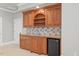 Kitchenette featuring wooden cabinets, tile backsplash, and a mini-fridge at 4708 Wynneford Way, Raleigh, NC 27614