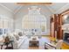 Living room with large windows, vaulted ceilings, hardwood floors, fireplace with built-ins, and ample seating at 4708 Wynneford Way, Raleigh, NC 27614