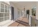 Covered porch featuring white pillars, wood floors, and a decorative hanging light at 4708 Wynneford Way, Raleigh, NC 27614