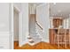 View of staircase with hardwood steps and patterned runner adjacent to kitchen breakfast bar at 4708 Wynneford Way, Raleigh, NC 27614