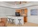 Home wet bar features seating for three, wood cabinetry, and black appliances at 4708 Wynneford Way, Raleigh, NC 27614