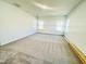 Large bedroom with neutral carpet, two windows, and ample natural light at 5161 Church Rd # 17, New Hill, NC 27562