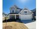 Charming two-story home featuring a two-car garage, light gray siding, and a well-manicured front lawn under a clear blue sky at 5161 Church Rd # 17, New Hill, NC 27562