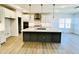 Open-concept kitchen with a large island, modern appliances, white cabinets, and stylish pendant lighting at 5161 Church Rd # 17, New Hill, NC 27562