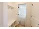 Mudroom entry with built-in bench and coat hooks, leading to bedroom featuring neutral carpet and a sunny window at 5161 Church Rd # 17, New Hill, NC 27562