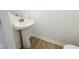 Compact powder room features a pedestal sink with a silver faucet and a clean, modern design on wood-look flooring at 5161 Church Rd # 17, New Hill, NC 27562
