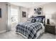 Relaxing bedroom featuring a window, a bed with plaid bedding, and two nightstands at 533 Freedom Trail Dr, Willow Springs, NC 27592