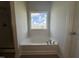 Bright bathroom featuring a soaking tub with chrome fixtures and a window with a view at 60 Commons Cir, Clayton, NC 27520