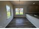 Bright dining area with wood floors, large windows, a modern chandelier, and access to the kitchen at 60 Commons Cir, Clayton, NC 27520