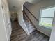 Inviting entryway featuring wood flooring, a staircase with wrought iron spindles, and natural light from a window at 60 Commons Cir, Clayton, NC 27520