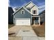 Two-story home featuring a front-facing garage and a mix of horizontal and shake siding at 60 Commons Cir, Clayton, NC 27520