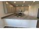 Spacious kitchen with granite countertops, gray cabinets, stainless steel appliances, and a stylish peninsula at 60 Commons Cir, Clayton, NC 27520