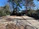 View of backyard with car port and driveway and mature trees at 606 N Orange Ave, Dunn, NC 28334