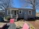 Back of home showing small patio and backyard area with shade trees and sitting area at 606 N Orange Ave, Dunn, NC 28334