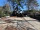 View of backyard with car port and driveway and mature trees at 606 N Orange Ave, Dunn, NC 28334