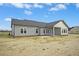 Rear exterior of home featuring gray siding, dark roof, and a back porch at 618 Tart Town Rd, Dunn, NC 28334