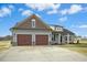 Charming exterior with a two-car garage, manicured lawn, and decorative stone accents at 618 Tart Town Rd, Dunn, NC 28334
