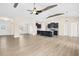Open concept living room featuring wood beams, ceiling fan, island kitchen, and light wood floors at 618 Tart Town Rd, Dunn, NC 28334