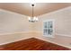 Bright dining room featuring hardwood floors, elegant lighting, and decorative wainscoting at 748 Weathergreen Dr, Raleigh, NC 27615