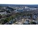 Aerial view featuring homes in a suburban neighborhood surrounded by lush green trees, roadways, and commercial districts at 857 Stroud Cir, Wake Forest, NC 27587