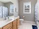This tidy bathroom has a simple vanity and a shower-tub combination with a bright blue curtain at 857 Stroud Cir, Wake Forest, NC 27587