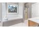 A bright bathroom offers both a walk-in shower and a soaking tub for ultimate relaxation at 857 Stroud Cir, Wake Forest, NC 27587