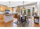Open kitchen with light wood cabinets adjacent to dining area and deck access at 857 Stroud Cir, Wake Forest, NC 27587