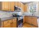 Kitchen showcasing stainless steel appliances, light wood cabinetry, and tile backsplash at 857 Stroud Cir, Wake Forest, NC 27587