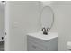 A vanity has gray cabinets and white countertop, a round mirror and stylish matte black faucet at 915 E Holly St, Rocky Mount, NC 27801