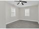 An empty bedroom features a modern ceiling fan, gray vinyl floors, and light-filled windows at 915 E Holly St, Rocky Mount, NC 27801