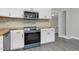 Close up of the modern kitchen showing white cabinets, stainless steel appliances, and wood countertops at 915 E Holly St, Rocky Mount, NC 27801